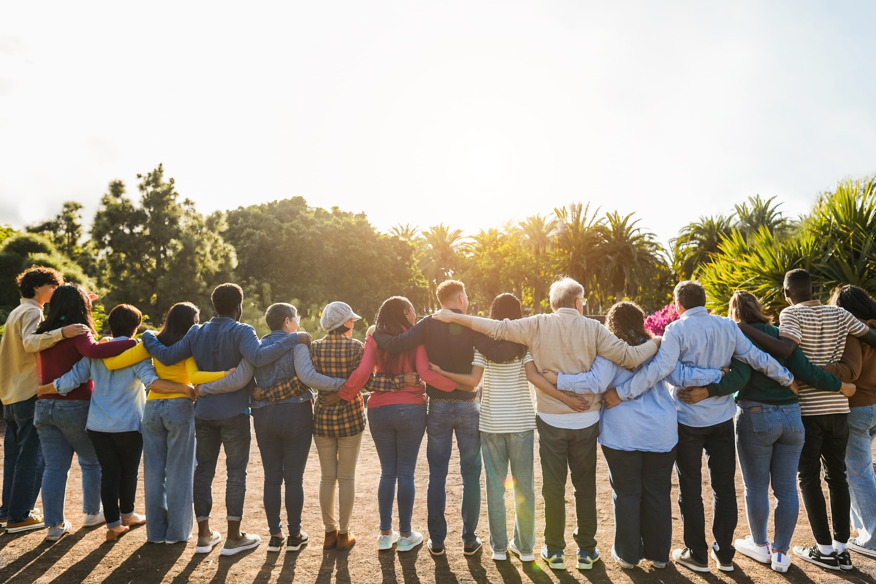 Groupe de personnes s'embrassant dans un parc — solidarité communautaire